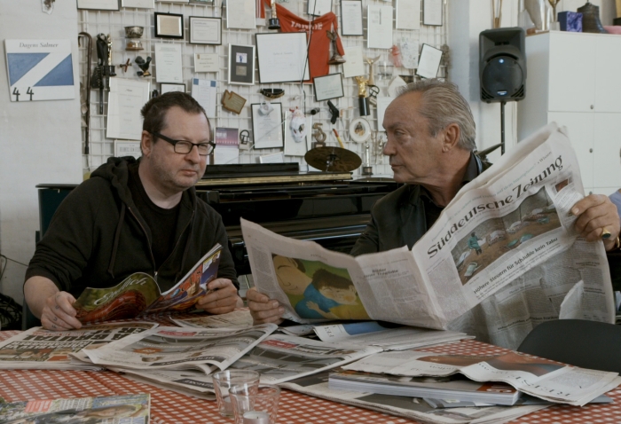 Udo Kier liest Zeitung mit Lars von Trier © Camino Filmverleih